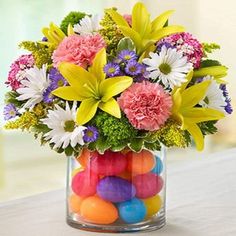 a glass vase filled with candy and flowers