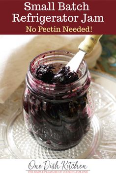 a jar filled with blueberries sitting on top of a glass plate