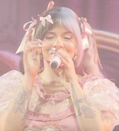 a woman in pink dress holding a microphone to her mouth