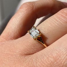 a woman's hand with a diamond ring on top of her finger and an engagement band