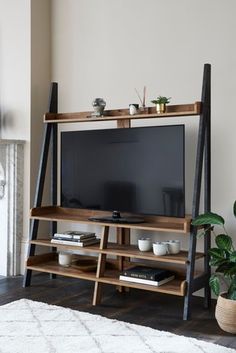 a living room with a large television on top of a wooden shelf