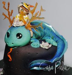 there is a cake decorated with a sea creature on it's head and an orange ribbon around its neck