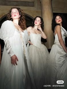 three models in white gowns standing next to each other