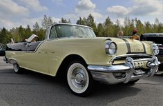 an old fashioned car parked in a parking lot