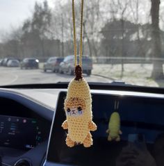 a stuffed animal hanging from the dashboard of a car