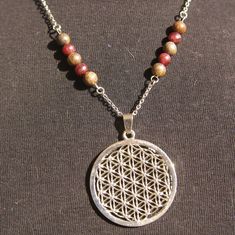 "Discover a Flower of life energy healing cristals necklaces for women or men.  This Inspirational necklace is associated with gemstones Grade A to allow us to rebalance, harmonize us. This Flower of life spiritual pendant is in alloy, it measures 40mm x 40 mm and the chains is in stainless steel.  Personalized your meditation jewelry with different lengths your choice.  This sacred geometry jewelry is the perfect talisman gifts, meditation gift for her, birthday gift, friendship gift for him, amulet alchemic gift, inspirational gift.  Many spiritual meanings are associated with this geometrical figure. For some,it is seen as a symbol that depicts the cycle of creation, and as such it has been accepted by different cultures and religions as the model of God's creation.  S I Z E ~ G U I D E Spiritual Round Pendant With Gemstone Beads, Spiritual Jewelry With Round Gemstone Pendant, Silver Necklaces With Natural Stones For Healing, Holistic Jewelry With 108 Beads For Gift, Spiritual Nickel-free Necklaces For Jewelry Making, Bohemian Flower Pendant Necklace For Meditation, Symbolic Gemstone Bead Necklaces For Gifts, Spiritual Necklaces With Natural Stones For Gifts, Spiritual Necklace With Round Natural Stone Pendant