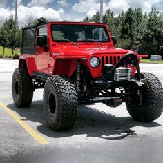 a red jeep parked in a parking lot