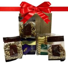 a gift bag filled with assorted chocolates and cookies next to a red ribbon