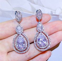 A delightfully unique pair of bridal earrings with an incredible sparkle! Adorned with flawlessly faceted cubic zirconia that capture the light in a dazzling array of sparkles, the earrings are rhodium plated for a bright finish which enhances the intricate detailing and conveys a modern take on old elegance. Overall length of the earring is 1.5" (approx. 4cm). Available in Silver, Rose Gold and Yellow Gold finishes. To make your choice select your preferred finish from the dropdown menu to add