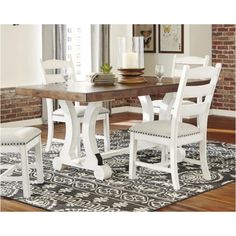 a dining room table with chairs and a rug