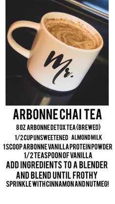 a cup of coffee sitting on top of a table next to a window with the words arbonne chai tea