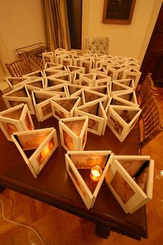 there are many frames with candles in them on the table