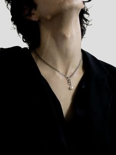 a woman wearing a black shirt and a necklace with a cross on it's neck