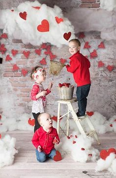 two children are standing on a ladder in front of hearts