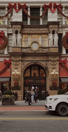 a car is parked in front of a building decorated with christmas wreaths and decorations