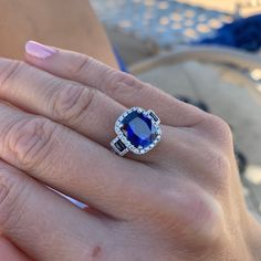 a woman's hand with a ring on it and a blue stone in the middle