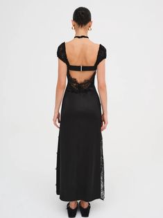 the back view of a woman wearing a black dress