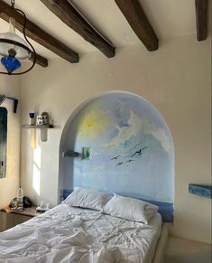 a large bed sitting in a bedroom next to a painting on the side of a wall