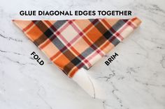 an orange and white plaid bandana with the words glue diagonal edges together on it