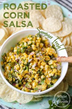 a bowl filled with corn salsa next to tortilla chips