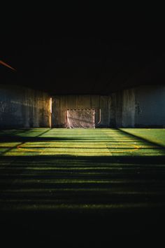 an empty soccer field in the dark with yellow lines on the grass and goal posts