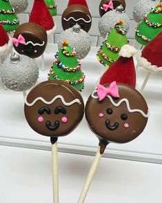 several chocolate covered candy lollipops with santa hats on them