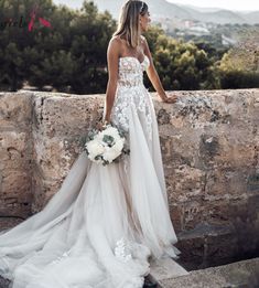 a woman in a wedding dress is standing on some steps and looking at the sky