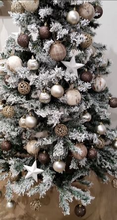 a white christmas tree with gold and silver ornaments