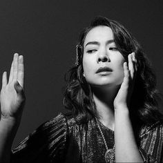 a black and white photo of a woman holding her hands up