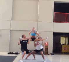 three people are doing acrobatic exercises in front of a building with windows