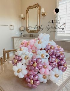 a bunch of balloons that are on top of a sink in a room with a mirror