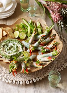 an assortment of vegetables and dip on a platter with crackers next to it