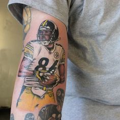 a man with a tattoo on his arm that has a football player holding a ball