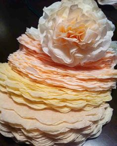 a large white flower sitting on top of a pile of cake frosted with icing