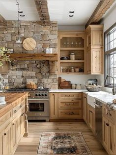 a kitchen with wooden cabinets and stone wall behind the stove top, along with an area rug on the floor