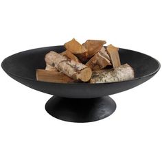 a black bowl filled with logs on top of a table