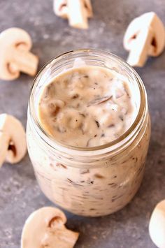 a glass jar filled with food sitting on top of a gray counter next to mushrooms