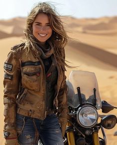 a woman standing next to a motorcycle in the desert