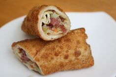 two burritos sitting on top of a white plate