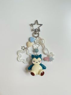 a keychain with a cat and other items attached to it on a white surface