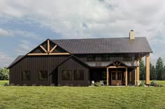 a large black house sitting on top of a lush green field