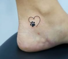 a small dog paw with a heart tattoo on it's side foot, which is black and white