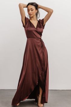 Feel glamorous in an instant with this stunning gown Luminous dark clove, purple brown color Satin material with slight stretch and lots of shine True wrap style with V-neckline Short flutter sleeves Wrap ties at waist loop through a hole in the side to tie Maxi length with tulip style skirt Silhouette creates movement and shows just enough leg Fully lined Self: 93% Polyester, 7% Spandex; Lining: 100% Polyester For larger busts, we recommend sizing is additional coverage is desired Sophia is 5'5 Burgundy Satin Floor-length Dresses, Solid Satin V-neck Maxi Dress, Solid Color Satin Maxi Dress With V-neck, Burgundy Satin V-neck Dress, Purple Satin Maxi Dress For Night Out, Brown Floor-length Evening Dress, Burgundy Fitted V-neck Maxi Dress, Brown Fitted Dress With Surplice Neckline, Elegant Brown Maxi Dress For Night Out