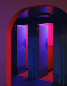 two open doors with red and blue lights in the room behind them are purple walls