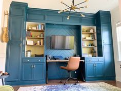 a living room with blue cabinets and a desk