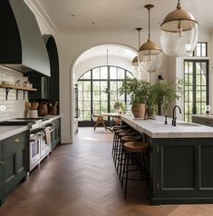 a large kitchen with an island and lots of counter space in front of the windows