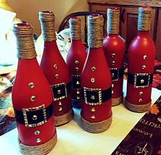 six red wine bottles decorated with gold and black decorations