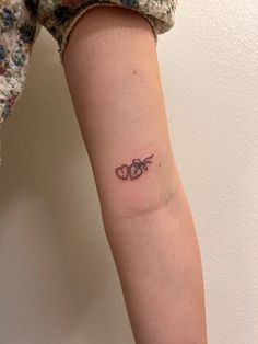 a small tattoo on the arm of a woman with two scissors in it's middle