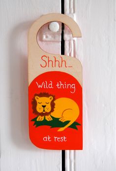 a wooden door hanger that says shh wild thing at rest with a lion on it