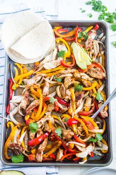 chicken fajita with peppers, onions and avocado on a sheet pan